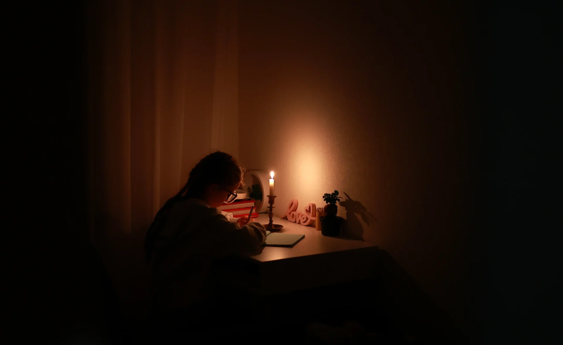 schoolgirl-uses-candlelight-to-writes-and-reads-in-power outage-Backup generators-free electrical quote